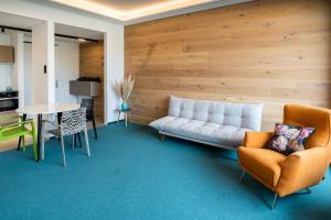 a living room with a couch and a table and chairs at LAKESIDE Apartements in Zwenkau