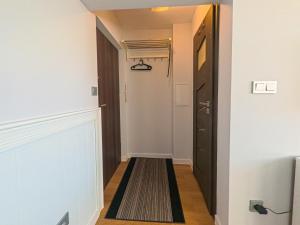 korytarz z czarnymi drzwiami i dywanem w obiekcie Apartament Parkowy Rabka w Rabce