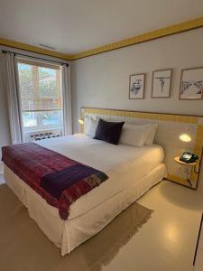 a bedroom with a large bed and a window at Hotel des Dunes in Cap-Ferret +25 photos