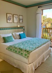 a large bed in a bedroom with a balcony at Hotel des Dunes in Cap-Ferret