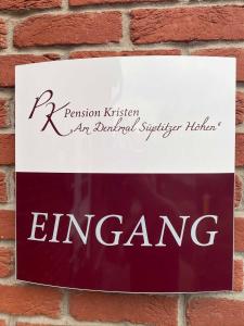 a sign on a brick wall with the name of a building at Pension und Ferienwohnung Kristen Am Denkmal Süptitzer Höhen in Zietenhof