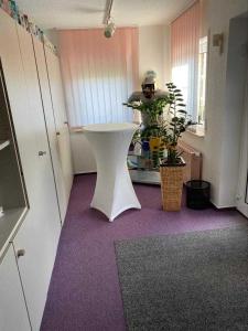 a man standing next to a white table in a room at Pension und Ferienwohnung Kristen Am Denkmal Süptitzer Höhen in Zietenhof