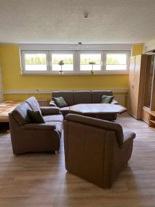 a living room with two couches and two tables at Pension und Ferienwohnung Kristen Am Denkmal Süptitzer Höhen in Zietenhof +6 photos