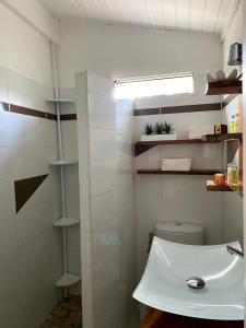 un bagno con un water bianco e un lavandino di Bungalow confortable à Sainte-Rose avec jardin privé_222 a Sainte-Rose