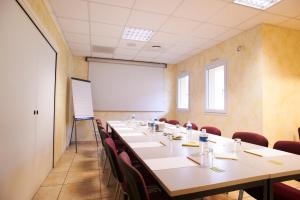 a conference room with tables and chairs and a whiteboard at Relais De La Grange in Nort-sur-Erdre