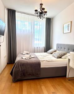a bedroom with a large bed with a chandelier at COZY PLACE NEAR BUS AND RAILWAY STATION with common kitchen, bathroom and toilet in Zagreb