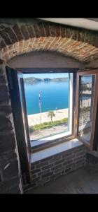 una ventana en un edificio de ladrillo con vistas al océano en Apartman Sun 2, en Šibenik