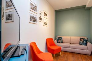 sala de estar con sillas de color naranja y sofá en Casa Mocambo by Toh Solution, en Turín