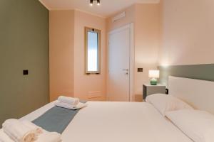 Un dormitorio con una gran cama blanca y una ventana. en Casa Mocambo by Toh Solution, en Turín