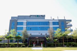 a building with a sign on the top of it at Green Palms Hotel and Resort in Kotah City