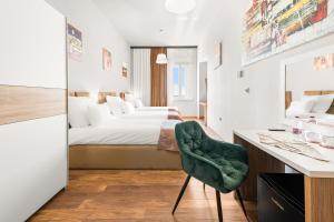 a bedroom with a bed and a desk and a chair at Hotel Dua Residence in Poreč