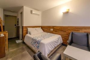 a bedroom with a bed and a desk and chairs at Jeju Dalbeach Pension in Jeju