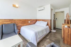 a bedroom with a bed and a chair in a room at Jeju Dalbeach Pension in Jeju