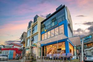 a blue and white building with a lot of windows at Jeju Dalbeach Pension in Jeju