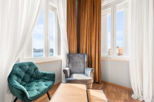 a living room with a chair and a table and window at Hotel Dua Residence in Poreč