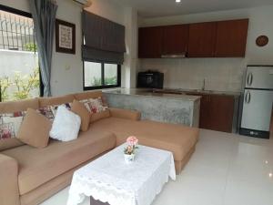 a living room with a couch and a table at Nern Khao Guest House in Kamala Beach