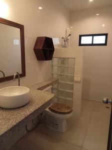 a bathroom with a sink and a toilet and a mirror at Nern Khao Guest House in Kamala Beach +19 photos
