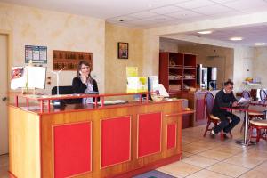 a woman talking on a cell phone at a counter at Relais De La Grange in Nort-sur-Erdre