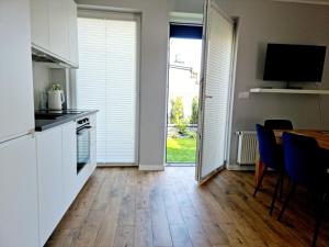 a kitchen and dining room with a table and a television at CIty Host Impresja P4 in Pabianice