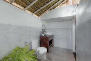 a bathroom with a toilet and a sink at Bhavana Cottage in Nusa Penida