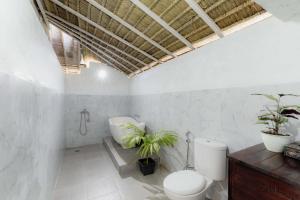 a bathroom with a toilet and plants in it at Bhavana Cottage in Nusa Penida +58 photos