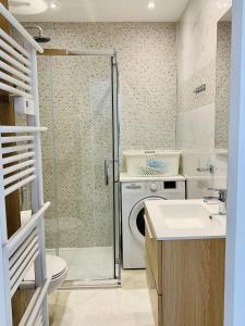 a bathroom with a washing machine and a sink at Appartement Saint-Raphaël in Saint-Raphaël