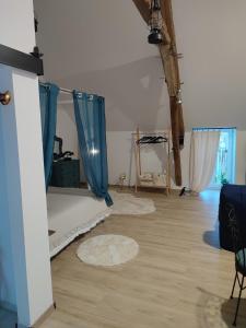 a room with a bed and blue curtains in it at Le nid du Berry in Célon
