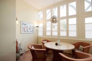 a room with a table and chairs and a window at Villa Malepartus by Rujana in Binz