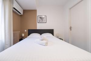 a bedroom with a white bed with towels on it at Le 303 Vault - Chambre Climatisée à Jean Jaurès in Toulouse