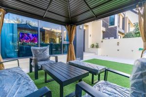 a patio with a table and chairs and a view of a building at NewArabian Dubai HillsMaple Villa in Dubai