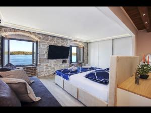 Un dormitorio con una cama grande y una pared de piedra. en Apartman Sun 2, en Šibenik