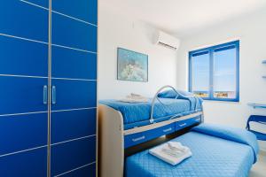 een slaapkamer met blauwe stapelbedden en blauwe kasten bij Dimora di Artemide in Otranto