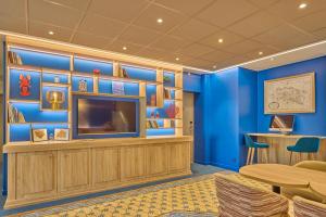 a room with blue walls and a tv and a table at Hôtel Le Jersey in Saint Malo +27 photos
