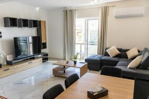 Una televisión o centro de entretenimiento en Brand New 3BR Apt in Gzira