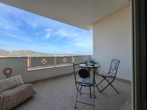 ein Wohnzimmer mit einem Tisch und Stühlen auf dem Balkon in der Unterkunft Francoforte 10 in Olbia