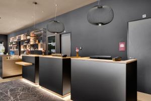 a bar with two pendant lights in a room at IntercityHotel Leiden in Leiden