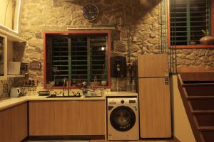 a kitchen with a refrigerator and a washing machine at Fifth Estate in Vagamon