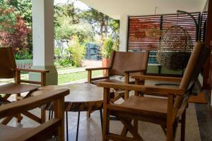 a group of wooden chairs and tables in a room at The Green House in Arusha