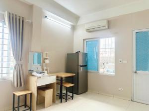 Una cocina con refrigerador y una mesa y sillas. en Warm Haven 501DM, en Hanói
