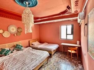 Habitación con 2 camas y escritorio. en 浪子小栈 Kashgar Ancient City, en Kashgar