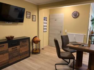 a living room with a desk and a television and a table at Gemütliches Apartment in Bodenfelde in Bodenfelde