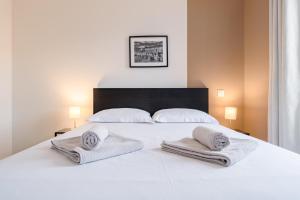 a bedroom with a white bed with towels on it at Solaria - Logement Climatisée à Jean Jaurès in Toulouse