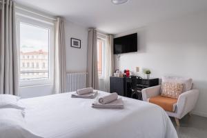 a bedroom with a bed and a chair and a window at Solaria - Logement Climatisée à Jean Jaurès in Toulouse