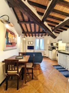 Una cocina y un comedor con mesa y sillas. en La Tana del Priore, en Perugia