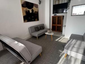 a living room with a couch and a chair and a table at Großzügiges Haus in Moselnähe in Neumagen-Dhron