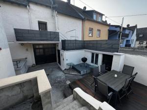 a patio with a table and chairs and a building at Großzügiges Haus in Moselnähe in Neumagen-Dhron