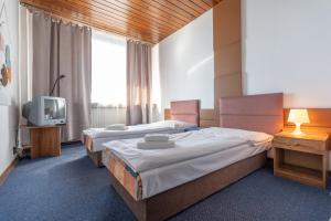 A bed or beds in a room at Hotel Slovakia
