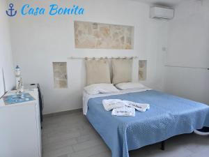 a bedroom with a bed with towels on it at Casa Bonita Pachino in Pachino