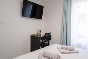 Habitación con cama y TV en la pared. en Wine & Four - Chambre Agréable sur les Allées, en Toulouse