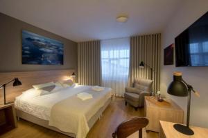 a hotel room with a bed and a chair at Hotel Gullfoss in Haukadalur